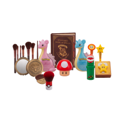 A collection of officially licensed pop-culture cosmetics and beauty tools from Harry Potter, Super Mario, and Pokémon, isolated on a transparent grid background. The set includes a Harry Potter 'Standard Book of Spells' palette and Golden Snitch compact mirror. Super Mario items feature a Question Mark block compact, Warp Pipe brush holder with Piranha Plant and Super Star tools, and a Mushroom container. Pokémon products include a Pokéball lip balm and two creature-shaped 'Pokéball Soothing Bath Wash' bottles. | Techbox